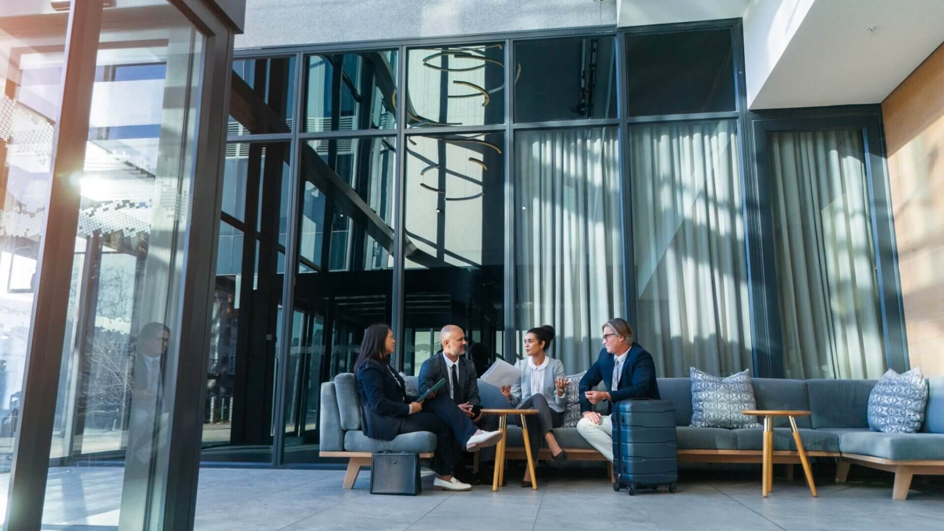 Business meeting in modern glass-walled office.